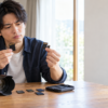 SDカードとmicroSDの形状の違いを見比べ、カメラに合うカードを確認する男性