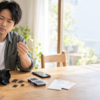 カメラやスマホ用のSDカードとmicroSDカードを手に取り、複数のカードを見比べる男性