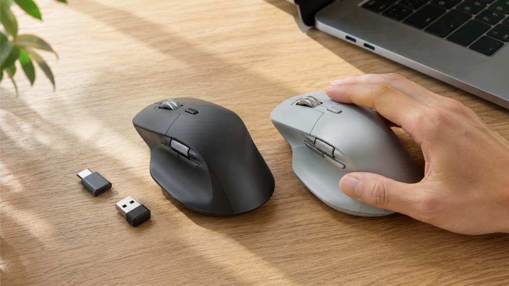USB-C型とUSB-A型の小型レシーバーを横に置き、形状の異なる2台のエルゴノミックマウスを手で比較する場面