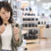家電量販店でSDカードとmicroSDカード、変換アダプターを手に取り形状を見比べる女性